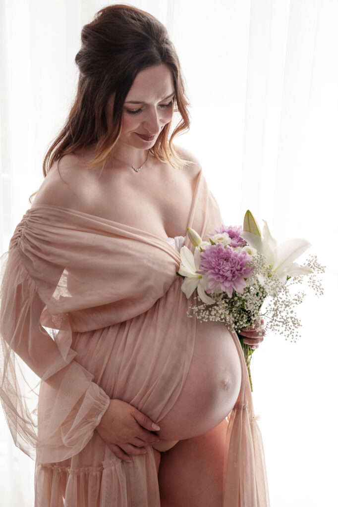 Schwangere Frau mit Parner und geliehenem Kleid beim Fotoshooting zuhause in Freilassing