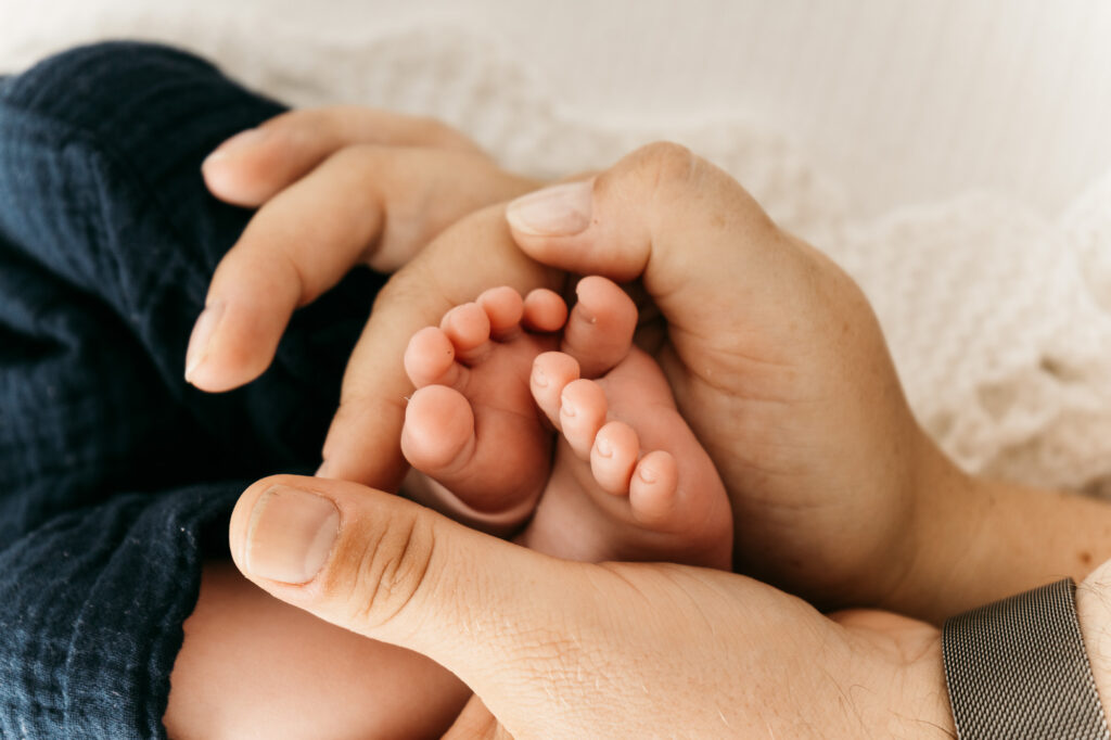 Papas Hände und Babyfüsse