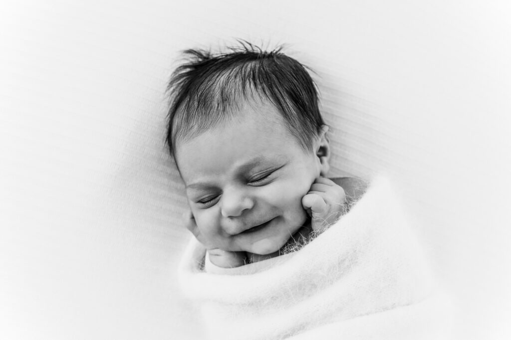 Baby lachend bei einem Neugeborenen-shooting bei Salzburg